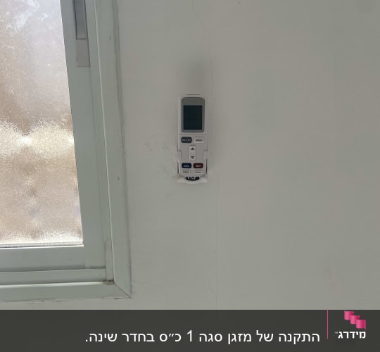 שלט רחוק למזגן תלוי על הקיר ליד חלון